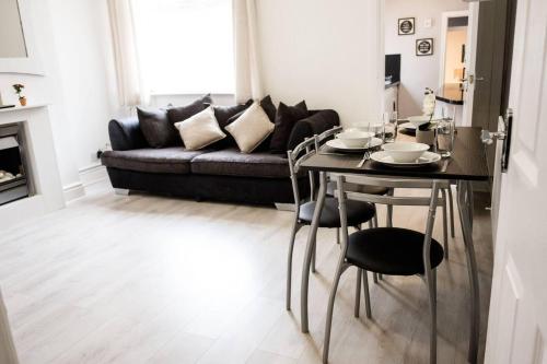 uma sala de estar com uma mesa e um sofá em Inspired Stays- Close to City Centre- 4 Bed House! em Ford Green