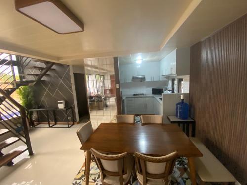a kitchen and dining room with a wooden table and chairs at Jill’s Maison in Bataan