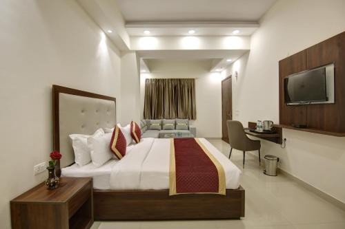 a hotel room with a bed and a television at Hotel La Mirage in Noida