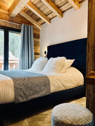 a bedroom with a large bed with a blue headboard at Hameau des Prodains - Résidence in Morzine