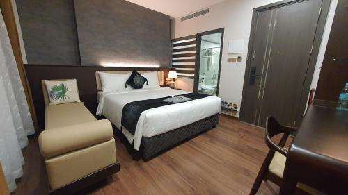 a hotel room with a bed and a chair at MOMIZI HANOI 2 - PHAN KE BINH in Hanoi