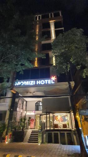 a hotel with a sign on the front of it at night at MOMIZI HANOI 2 - PHAN KE BINH in Hanoi