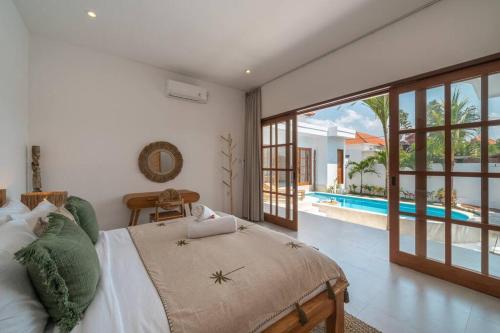 una camera da letto con un letto e una piscina di CASA BIARI : Tropical Vibes - 3 min from beach a Canggu