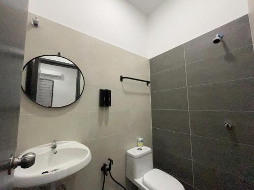 y baño con aseo blanco y espejo. en Armaya Pool Villa Klang en Klang