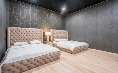 a bedroom with two beds and a wall with tiles at Urban Villa By Umbrella in Tbilisi City