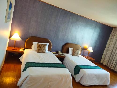 Ένα ή περισσότερα κρεβάτια σε δωμάτιο στο Thumrin Thana Hotel