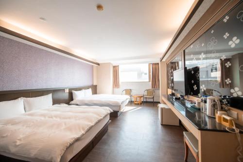 a hotel room with two beds and a television at 台中灣文旅 T C ONE Hotel in Taichung