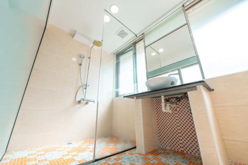 W łazience znajduje się szklana kabina prysznicowa i umywalka. w obiekcie 台中灣文旅 T C ONE Hotel w mieście Taizhong