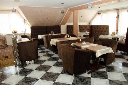 a restaurant with tables and chairs and a checkered floor at Hotel VIZA in Solotvyno