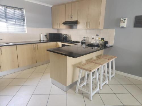 a kitchen with a counter and some stools in it at INNIKOL 55 in Mossel Bay