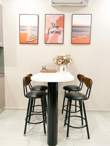 a table with four chairs in a room with pictures at VIP THE SÓNG APARTMENT NEAR THE BEACH 5 STAR - FREE INFINITy in Vung Tau