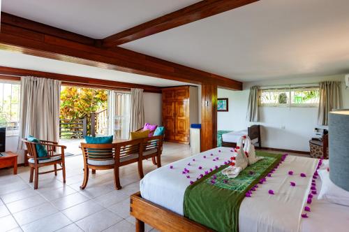 a bedroom with a bed and a table and chairs at Chalets Cote Mer in Baie Sainte Anne