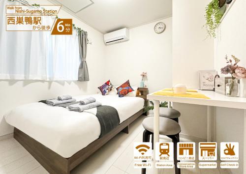 two beds in a room with a table and a desk at nestay villa tokyo sugamo in Tokyo