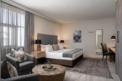 um quarto de hotel com uma cama, um sofá e uma mesa em Protea Hotel by Marriott Walvis Bay Indongo em Walvis Bay