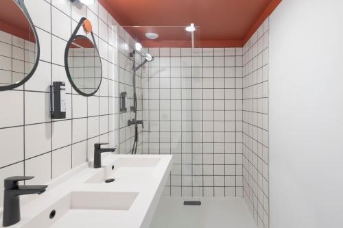 a bathroom with two sinks and two mirrors at Quai Central in Tourcoing