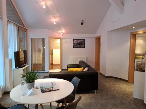 a living room with a couch and a table at Edelweiss Apartments 200m zum Lift - Silvretta Card Premium Inklusive in See