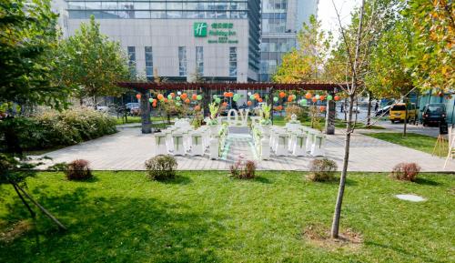 a group of chairs and a table in a park at Holiday Inn Beijing Focus Square by IHG in Beijing