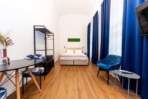 a room with a bed and a table and chairs at Adagio Downtown Rooms in Budapest