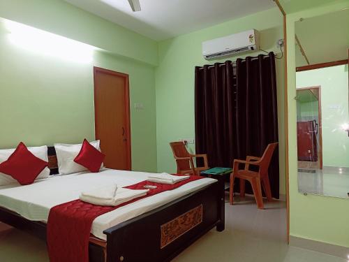 a bedroom with a bed with red pillows at Ananya service apartments in Chennai