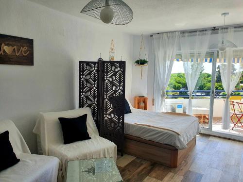 sypialnia z łóżkiem, krzesłem i oknem w obiekcie Arabia´s Loft Nuevo Portil w mieście El Portil