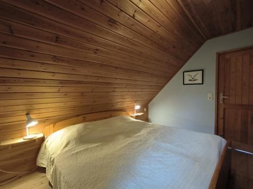 Bett in einem Zimmer mit Holzdecke in der Unterkunft Ulmenhof Melfsen in Oeversee