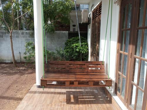 a wooden bench sitting on the porch of a house at Anne's Homestay in Gampaha