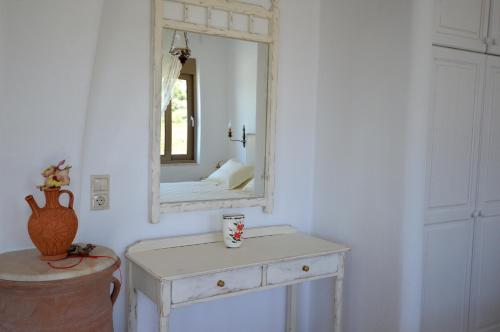 a white dressing table with a mirror on a wall at Bianca Suite & Home in Psinthos