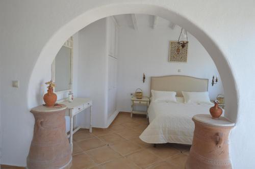 a bedroom with an archway with a bed and a table at Bianca Suite & Home in Psinthos