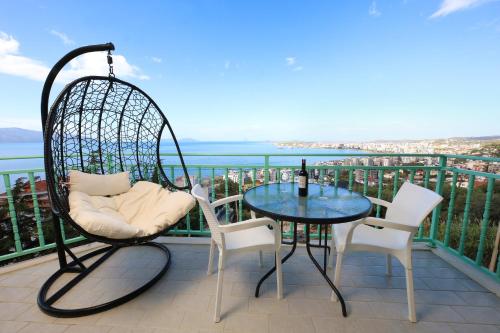 a swing chair and a table on a balcony at Rezidenca Panorama Apartments in Vlorë