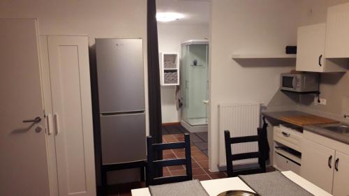 een keuken met een koelkast en 2 stoelen. bij STUDIO Wohnung 34m², Kreuzbergl (1-2 Gäste) in Klagenfurt