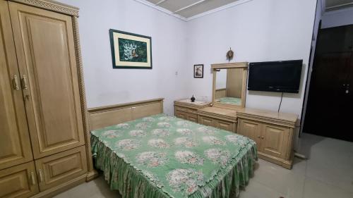 a bedroom with a bed and a mirror and a television at WKNDR Zone in Jakarta