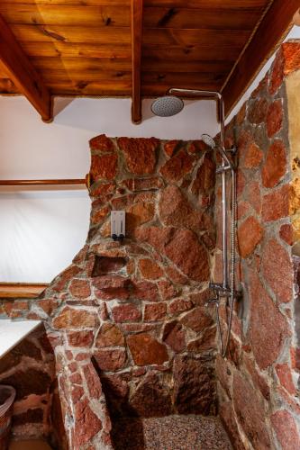 a stone wall with a shower in a room at Colibri Hotel in Baie Sainte Anne
