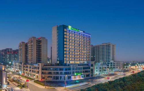 un edificio iluminado en una ciudad por la noche en Holiday Inn Express Mianyang Sci-Tech City, an IHG Hotel en Mianyang