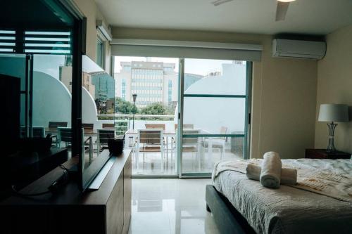 聖胡安的住宿－Spacious Comfy PH Apt for 9 @ San Juan - Miramar 4 - Nuevo，一间卧室设有一张床和一个大型玻璃窗