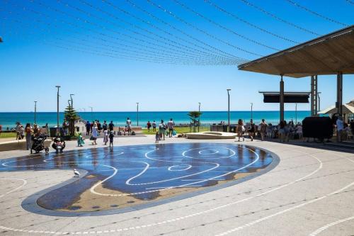 a crowd of people walking around a fountain near the beach at Heart of Henley - A Homey Hideaway by the Beach in Adelaide
