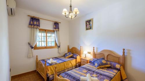 - une chambre avec 2 lits et une fenêtre dans l'établissement Cortijo La Encina Sayalonga by Ruralidays, à Sayalonga