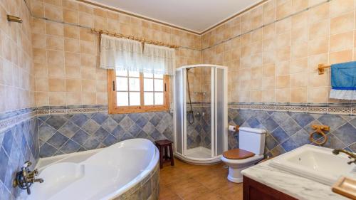 a bathroom with a tub and a toilet at Cortijo La Encina Sayalonga by Ruralidays in Sayalonga