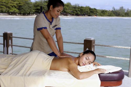 un hombre dándole a una mujer un masaje en una cama en Independence Hotel Resort & Spa, en Sihanoukville