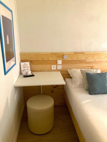 a small room with a desk and a bed at Résidence Thibaud in Toulouse