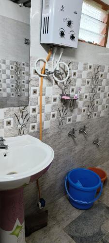 a bathroom with a sink and faucet at Raagabynature home stay in Gendehalli