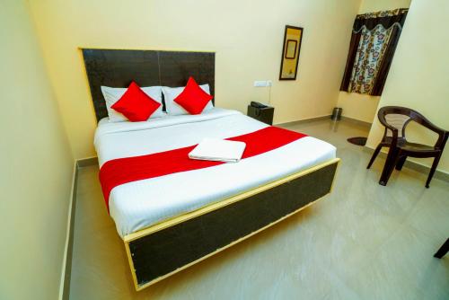1 dormitorio con 1 cama grande con almohadas rojas en Ssunshhine residency (NEW) en Tirupati