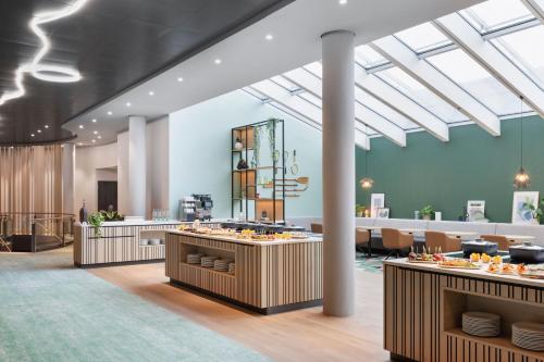 a rendering of a restaurant with tables and chairs at Courtyard by Marriott Basel in Pratteln