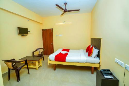 um quarto com uma cama, uma secretária e uma televisão em Ssunshhine residency (NEW) em Tirupati