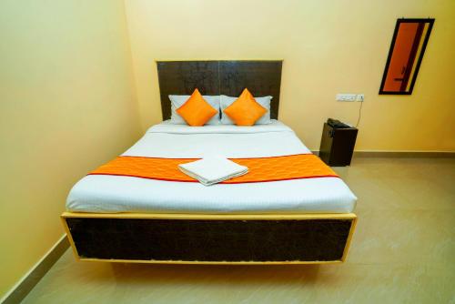 a bedroom with a bed with orange and white sheets at Ssunshhine residency (NEW) in Tirupati