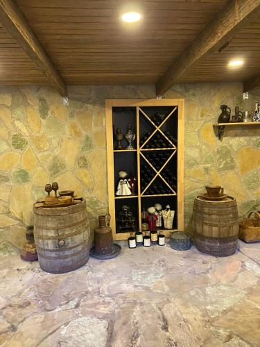 a room with barrels and a shelf of wine bottles at სასტუმრო ამელი/Hotel Ameli in Tʼelavi