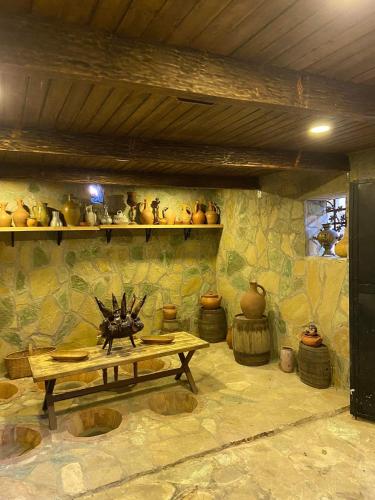 a room with a table and vases on a wall at სასტუმრო ამელი/Hotel Ameli in Tʼelavi