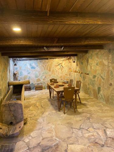 a dining room with a table and chairs in a stone wall at სასტუმრო ამელი/Hotel Ameli in Tʼelavi