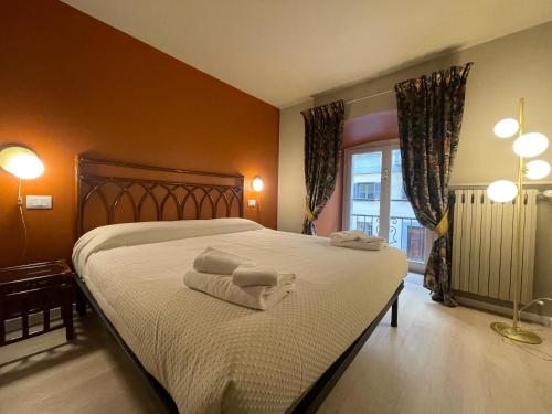 een slaapkamer met een groot bed met handdoeken erop bij Obelisque 1850 con posto auto! in Turijn
