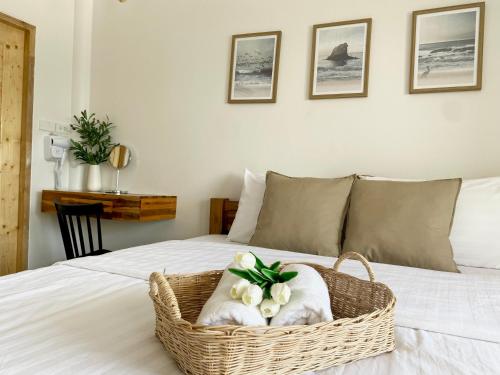 um quarto com um cesto de flores numa cama em The O room em Ko Larn