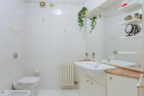 a white bathroom with a sink and a toilet at Yourbanflat Monte Rosso in Teolo